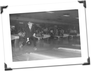 black and white photo of man bowling in suite